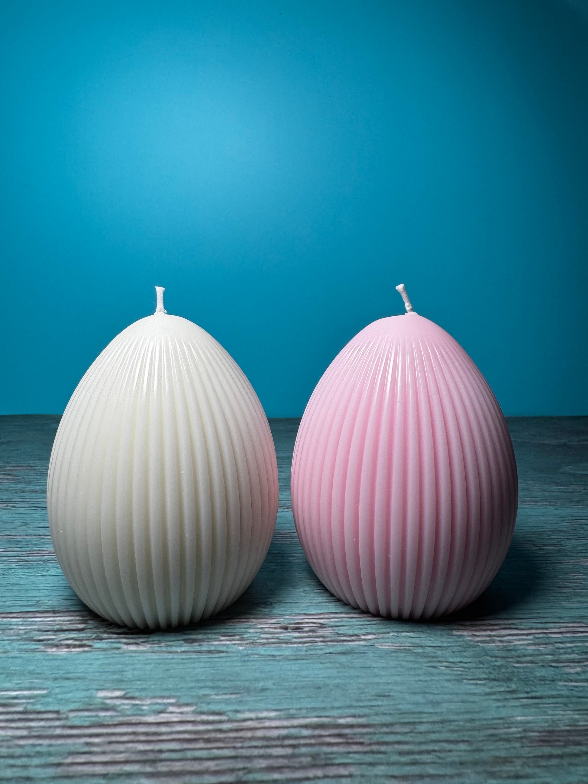 candele a forma di uovo di colore bianco e rosa