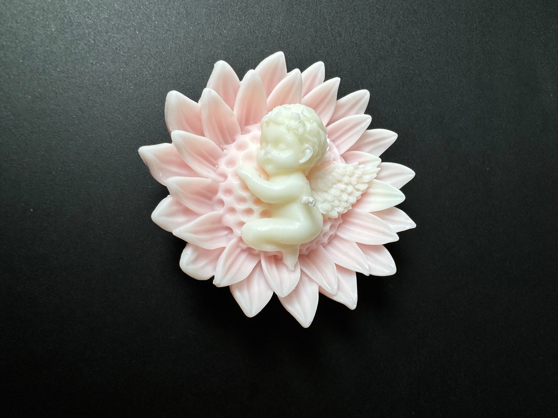 candela angioletto con ali mentre dorme su fiore