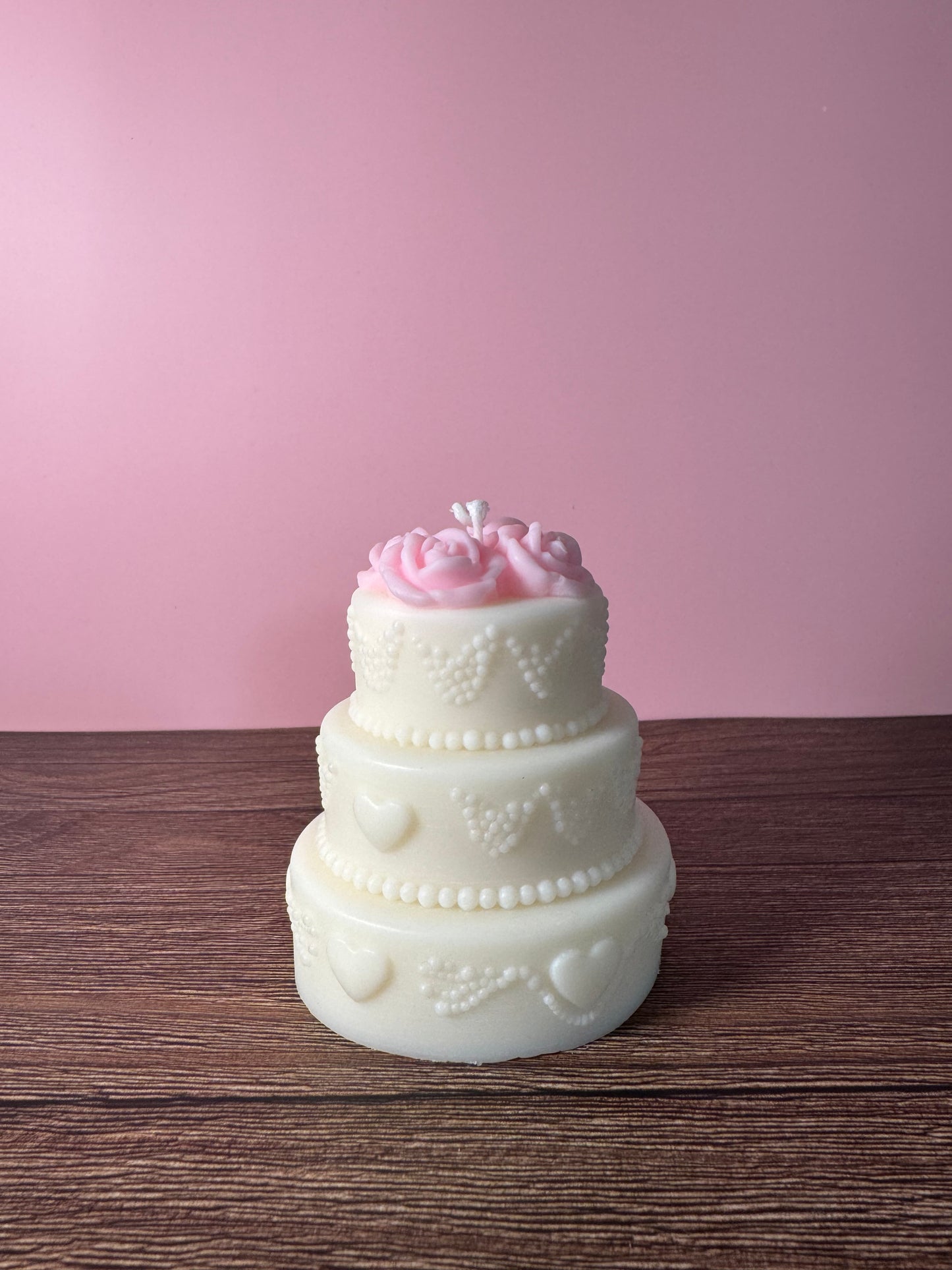 candela profumataa forma di torta decorativa  con delle rose sopra e dei cuori di lato